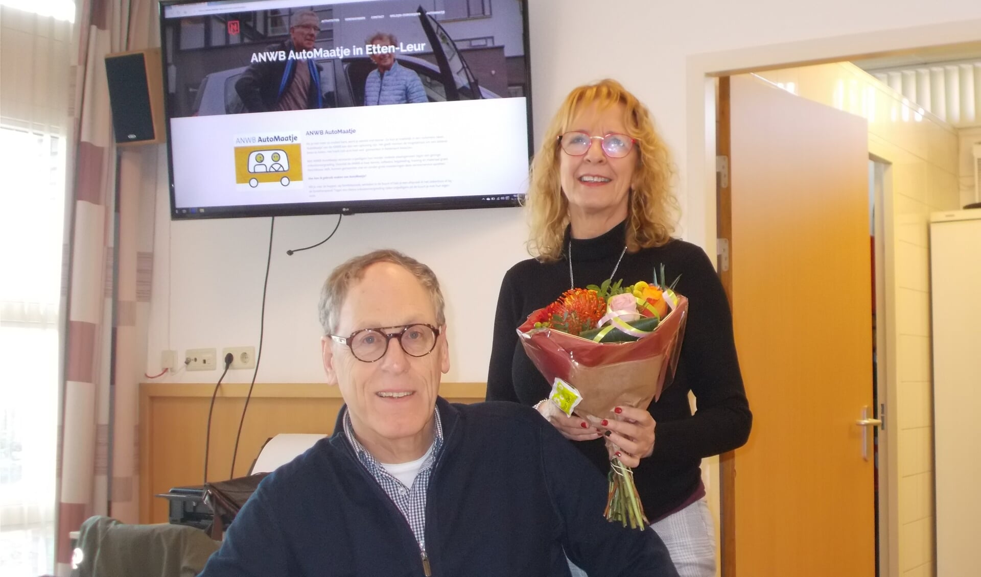Jaap Lucieer overhandigt coördinator Els de Lange van AutoMaatje bloemen. 