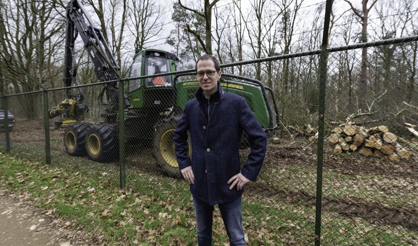 Wethouder Martien de Bruijn met de kapwerkzaamheden op de achtergrond.
