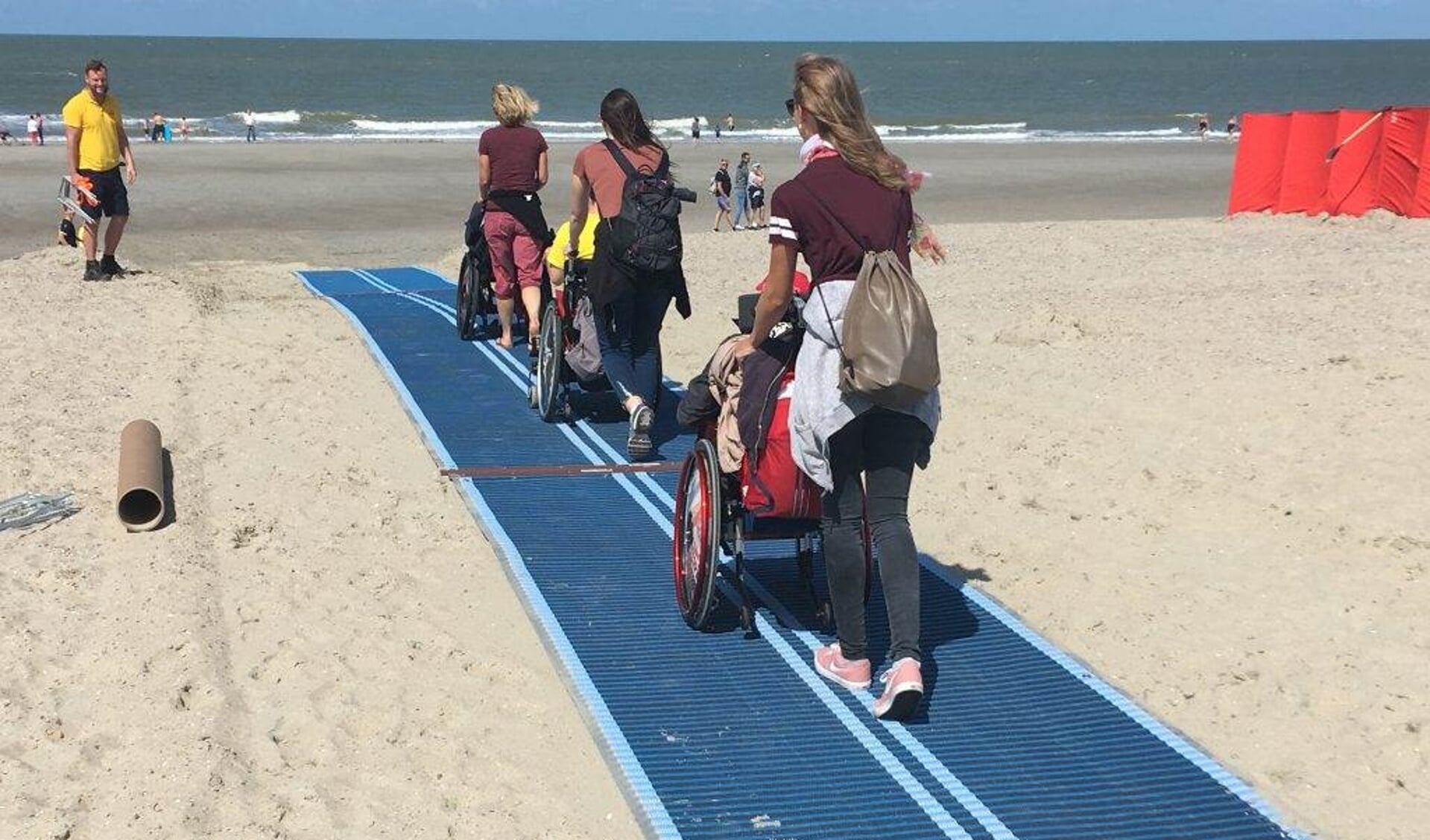 Een mobi-mat helpt rolstoelers het strand op.