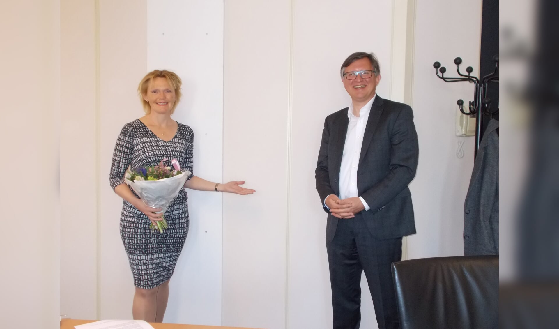 Directeur Hilda Vliegenthart van de Nieuwe Nobelaer ontvangt bloemen van wethouder Ger de Weert. 