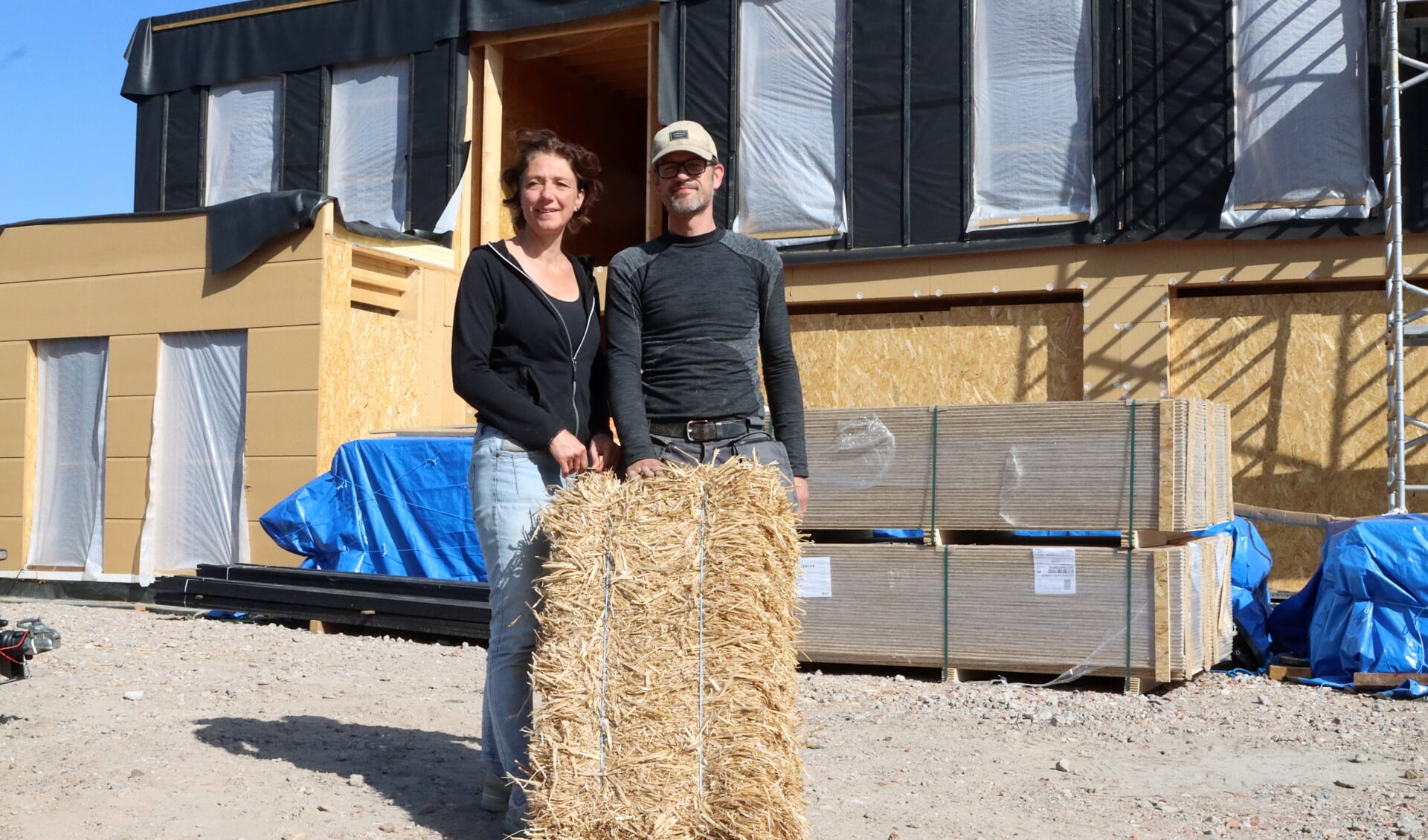 Elsbeth en Martijn Jansen voor hun strohuis in aanbouw. FOTO COBY WEIJERS