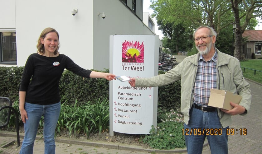 Arie van Kralingen overhandigt de Zeeuws Mannenkoor CD aan Suzanne Bassie van Ter Weel.