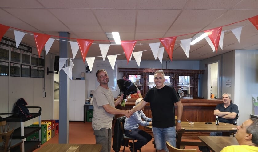 Falco krijgt de bloemen en wordt gefeliciteerd door de voorzitter.