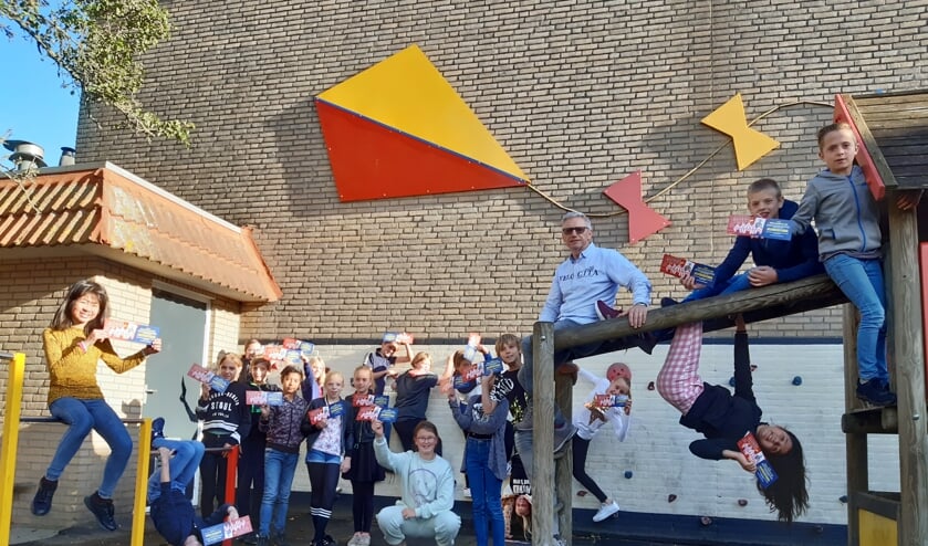 <p>Meester Alfons te midden van zijn geliefde leerlingen met de uitnodigingen voor de circusshow.</p>