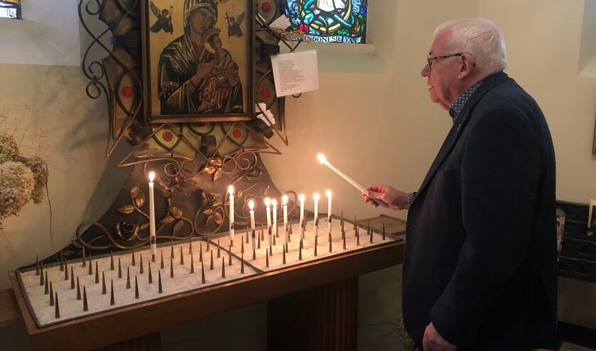 <p>Jan van Steenoven steekt een kaars op in de Mariakapel.</p>