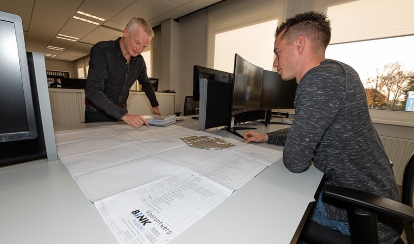 <p>John Antens (links) met een collega aan de ontwerptafel.</p>