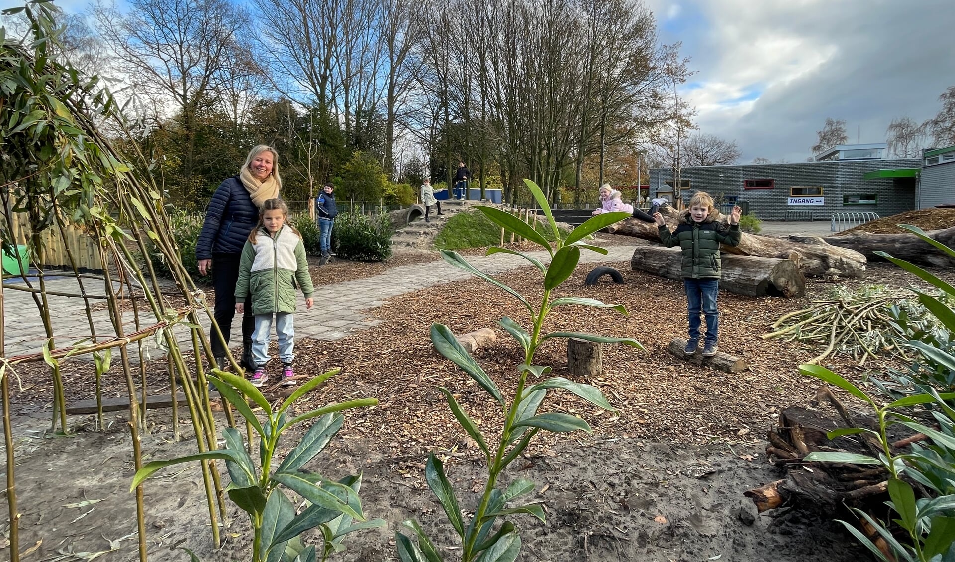 Anne van Loon met enkele kinderen op het nieuwe natuurspeelplein