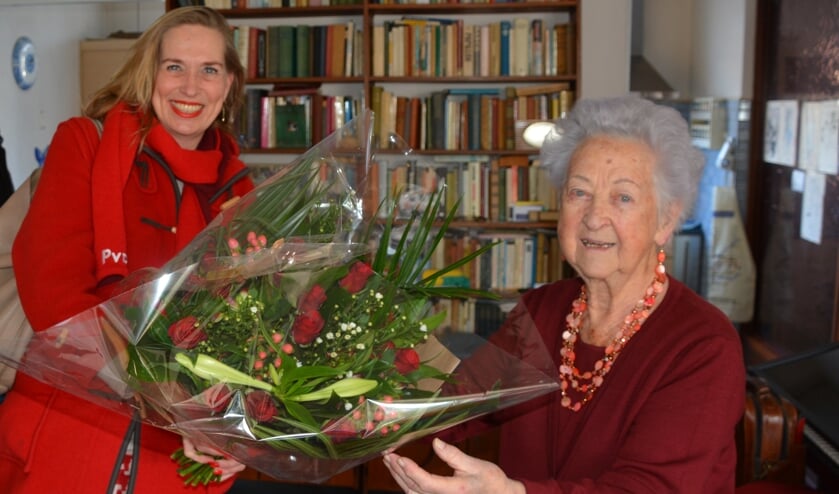 <p>Jubilaris Sophia Mensen krijgt rode rozen van kandidaat-Tweede Kamerlid Barbara Oomen.</p>  