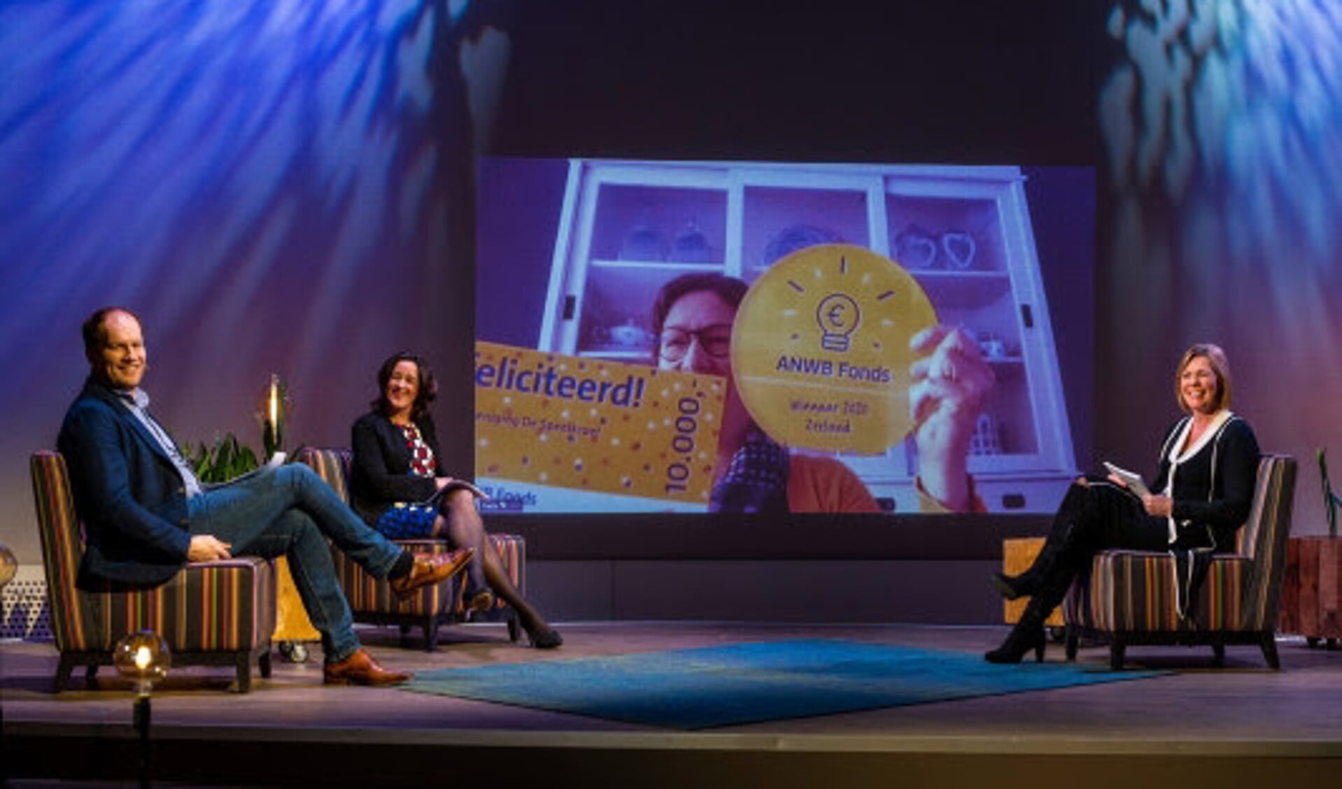 Peter Sieuwers, Aannemarie Gerards en Marga de Jager (Directeur merk en leden) Op het beeldscherm de Thoolse winnares Joline Jansen.