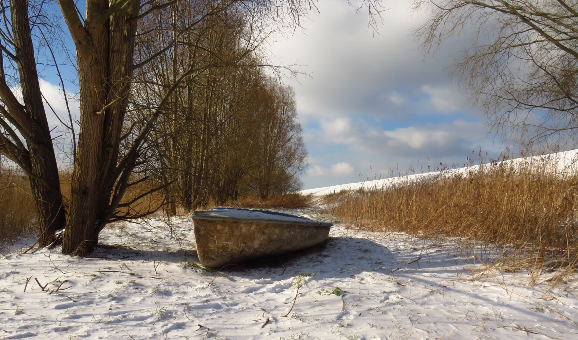 Een sfeervolle foto van een oude boot in de sneeuw bij Krabbendijke.