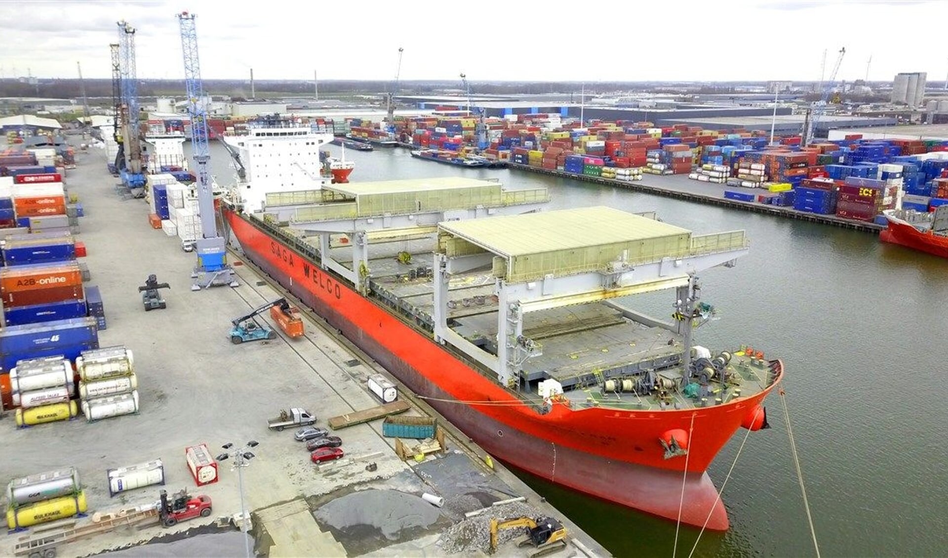 Een enorm containerschip in de haven.