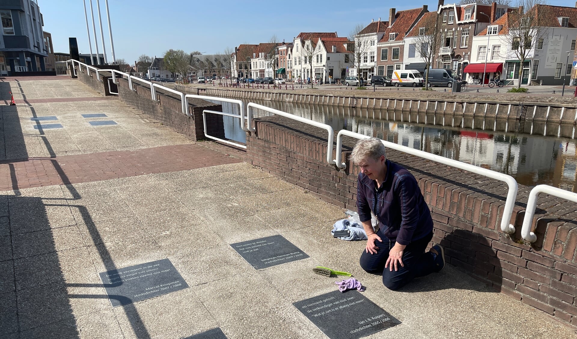 El van Hal legt de laatste hand aan de tegelgedichten op de Kousteensedijk in Middelburg