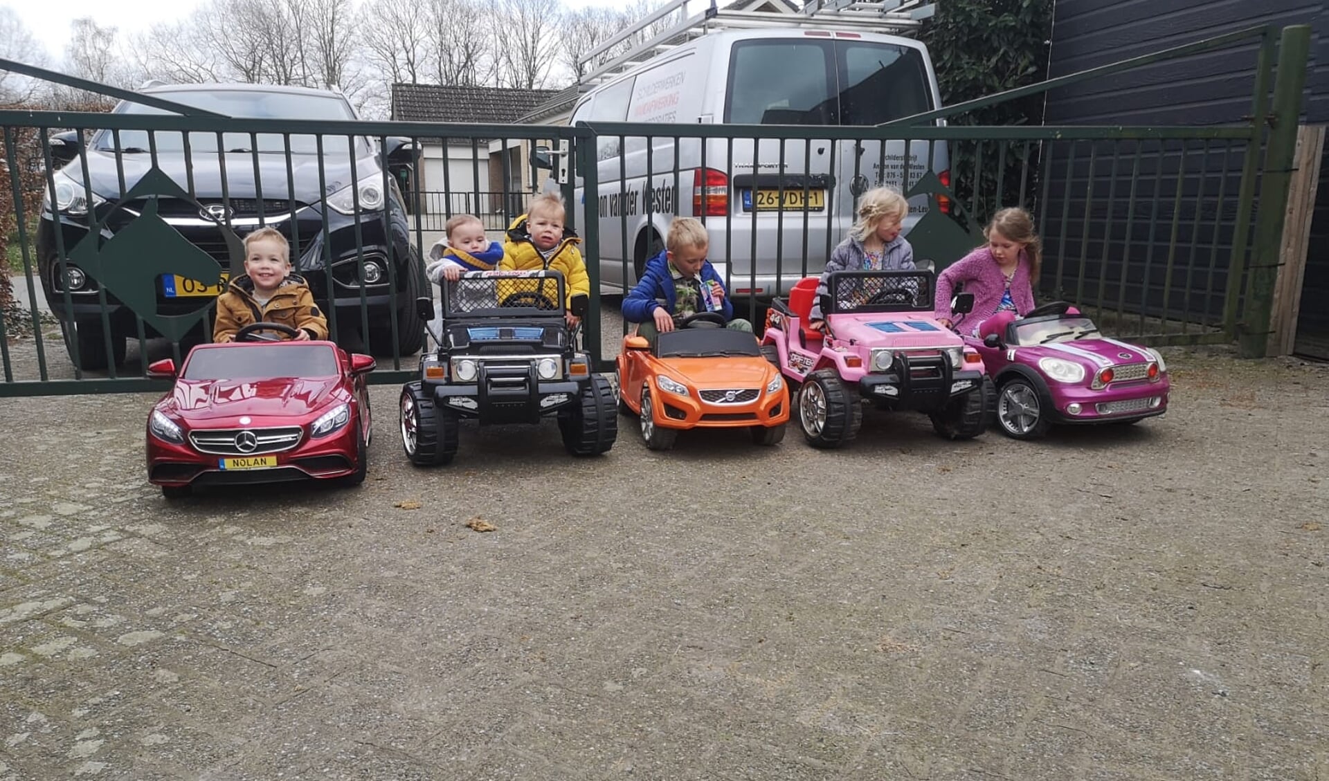 De kleinkinderen op visite in hun eigen auto.
