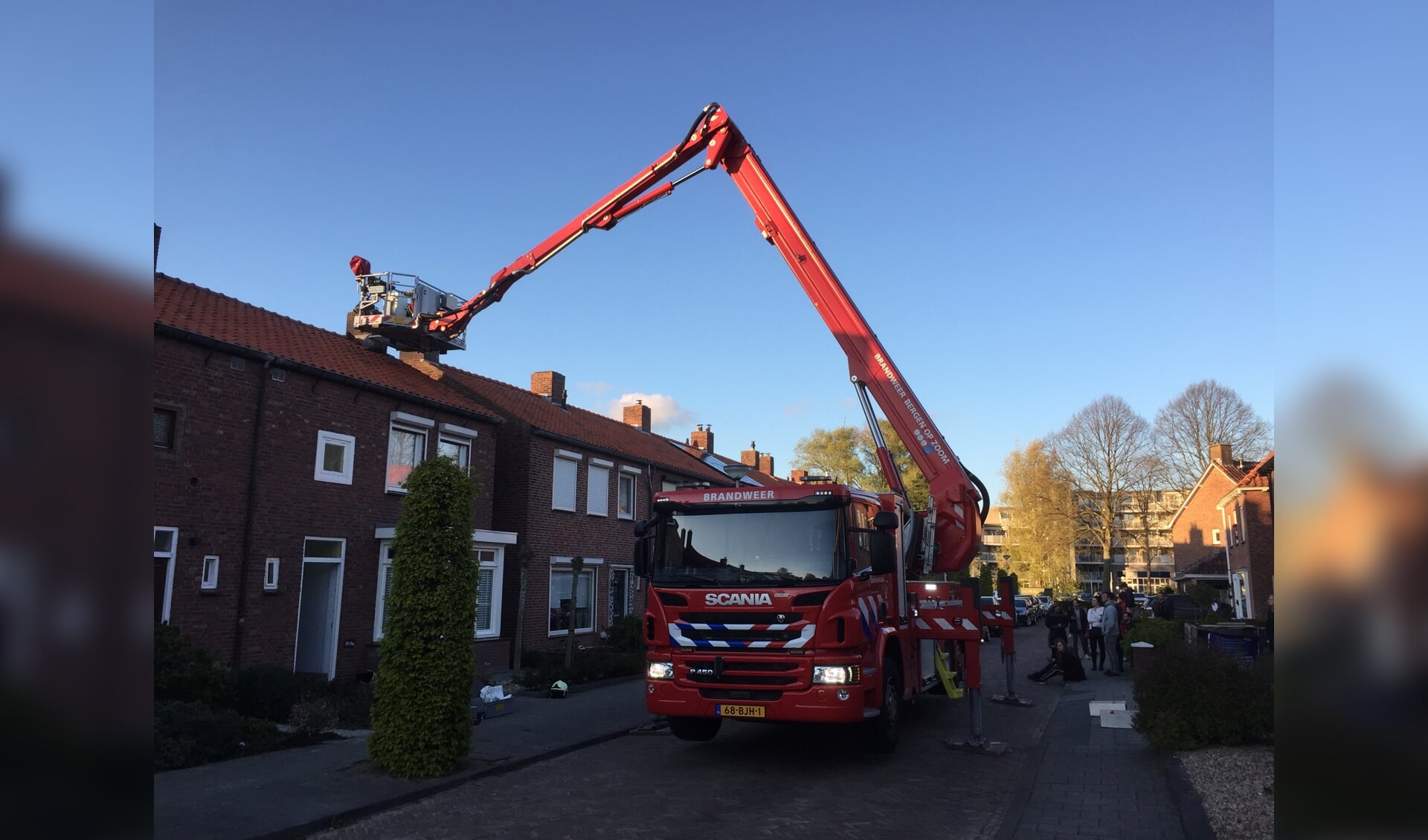 Hoogwerker van Brandweer Bergen op Zoom lost schoorsteenbrand op in Emmastraat