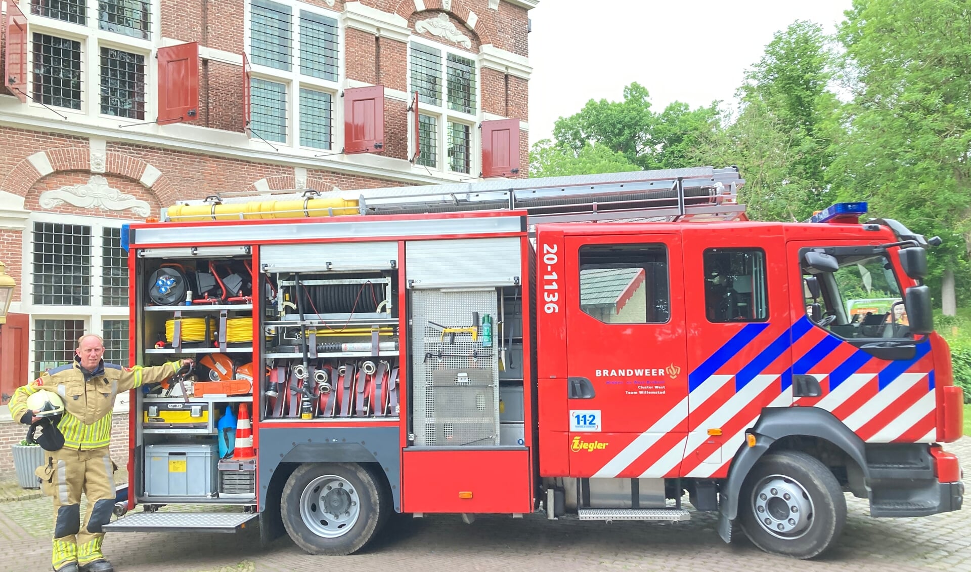 Alko Knook bij de brandweerwagen van Willemstad. 