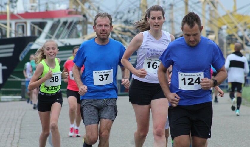 Enkele deelnemers tijdens de Sportvisserloop lopende langs de havens.