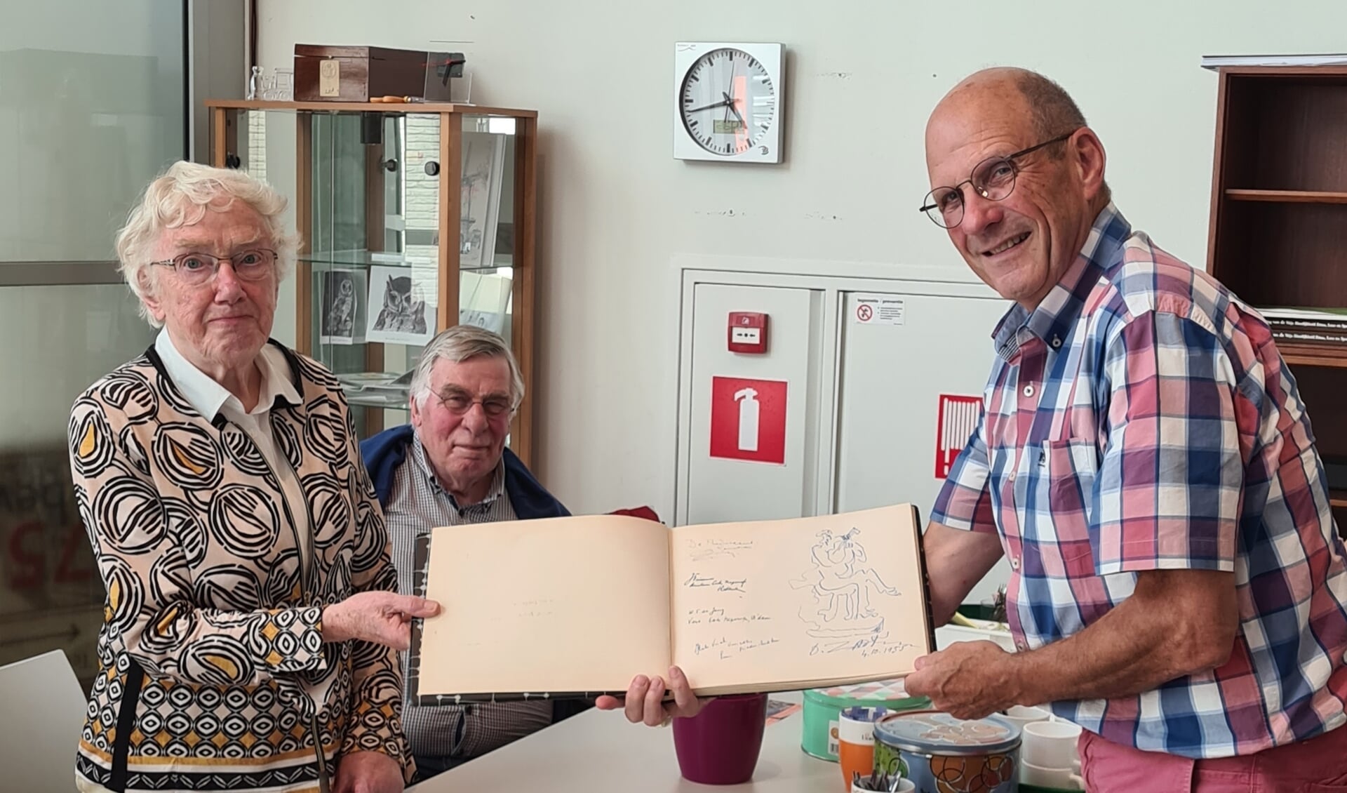 Tomado-secretaresse Willy van Eyk overhandigt een receptiealbum aan Piet Paantjens van de Heemkundekring Jan uten Houte.