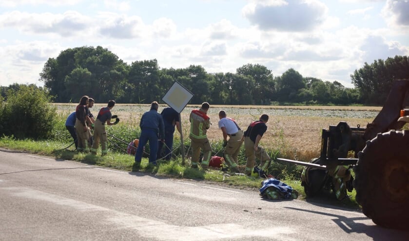 Hulpverleners doen een poging het paard uit de sloot te trekken langs de Prelaatweg