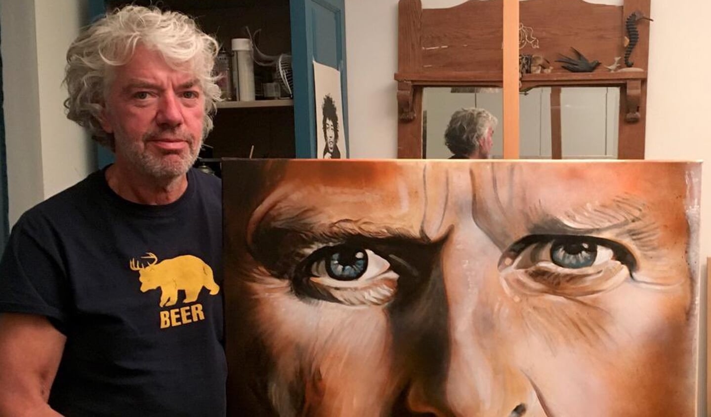 Kunstenaar Henk de Beer met zijn portret.