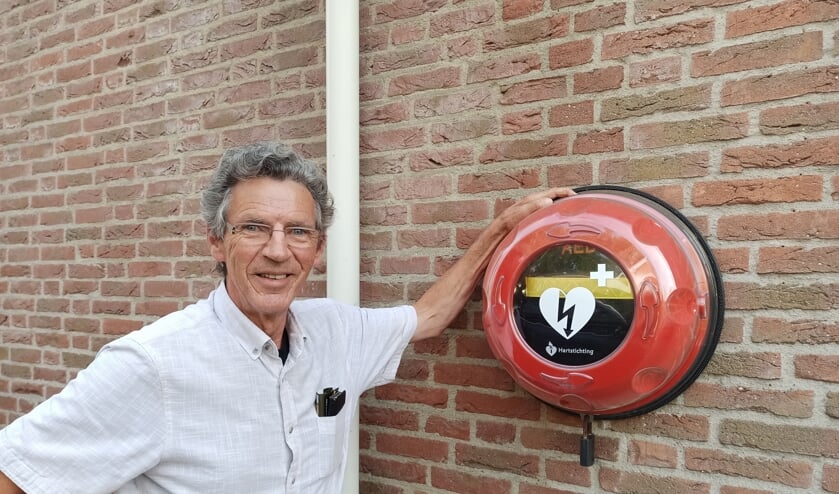 <p>John Schuurmans bij de AED aan zijn huis.</p>