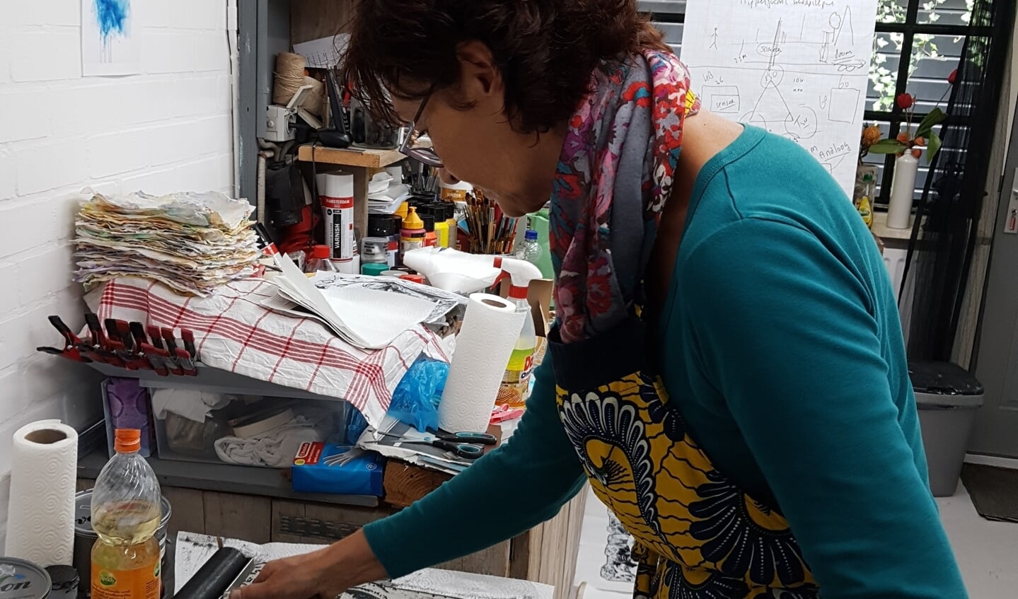 Anneke Hansum bezig met het inrollen van een Linosnede.