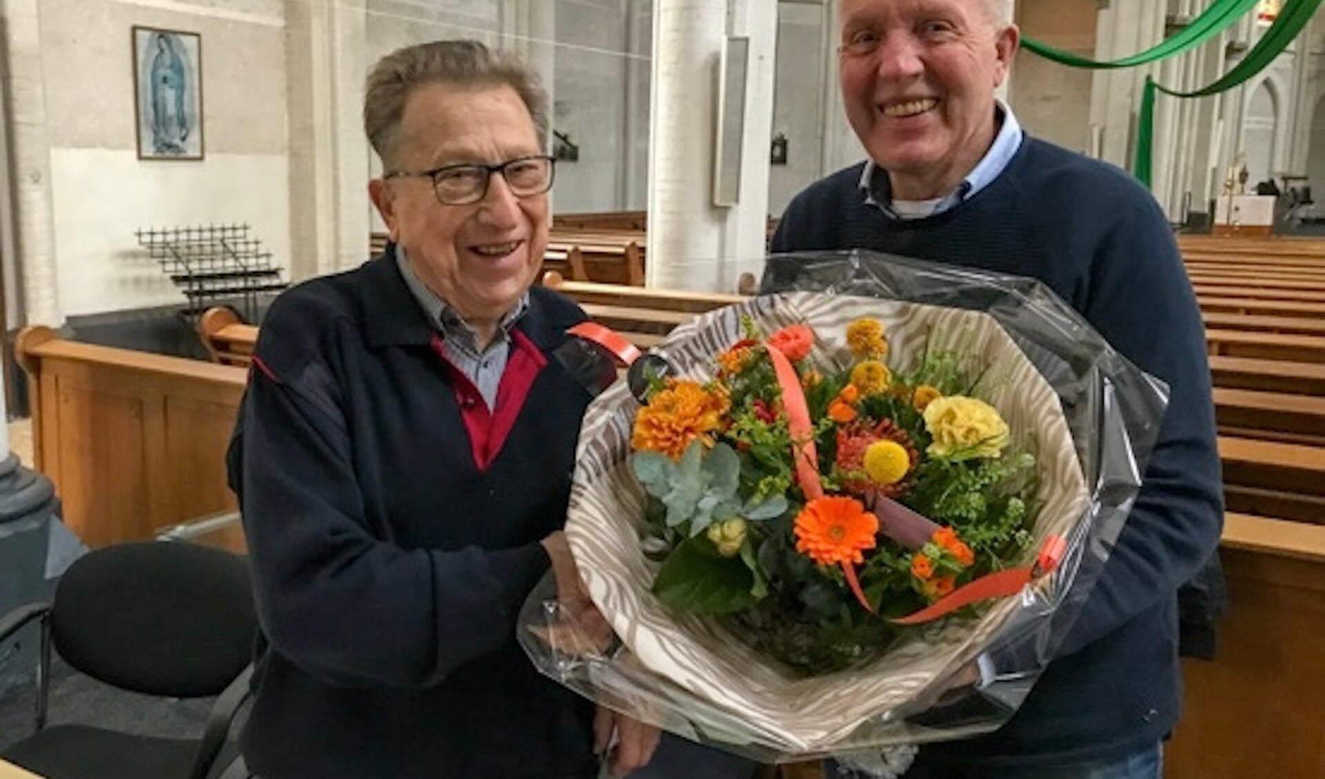 Kees Leijten (L) krijgt bloemen van Jos Heestermans namens parochiebestuur