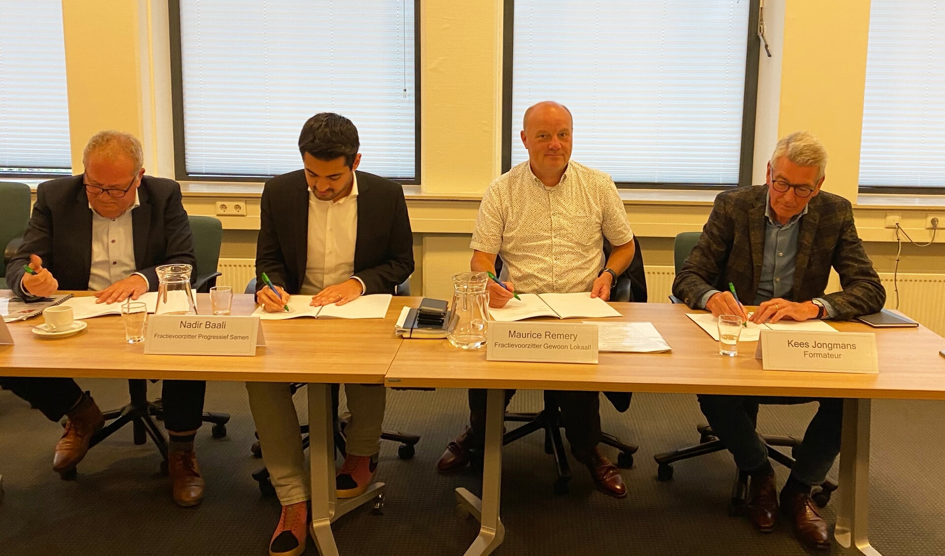 Fractievoorzitters Kees Gommeren, Nadir Baali, Maurice Remery en formateur Kees Jongmans ondertekenen het coalitieakkoord.