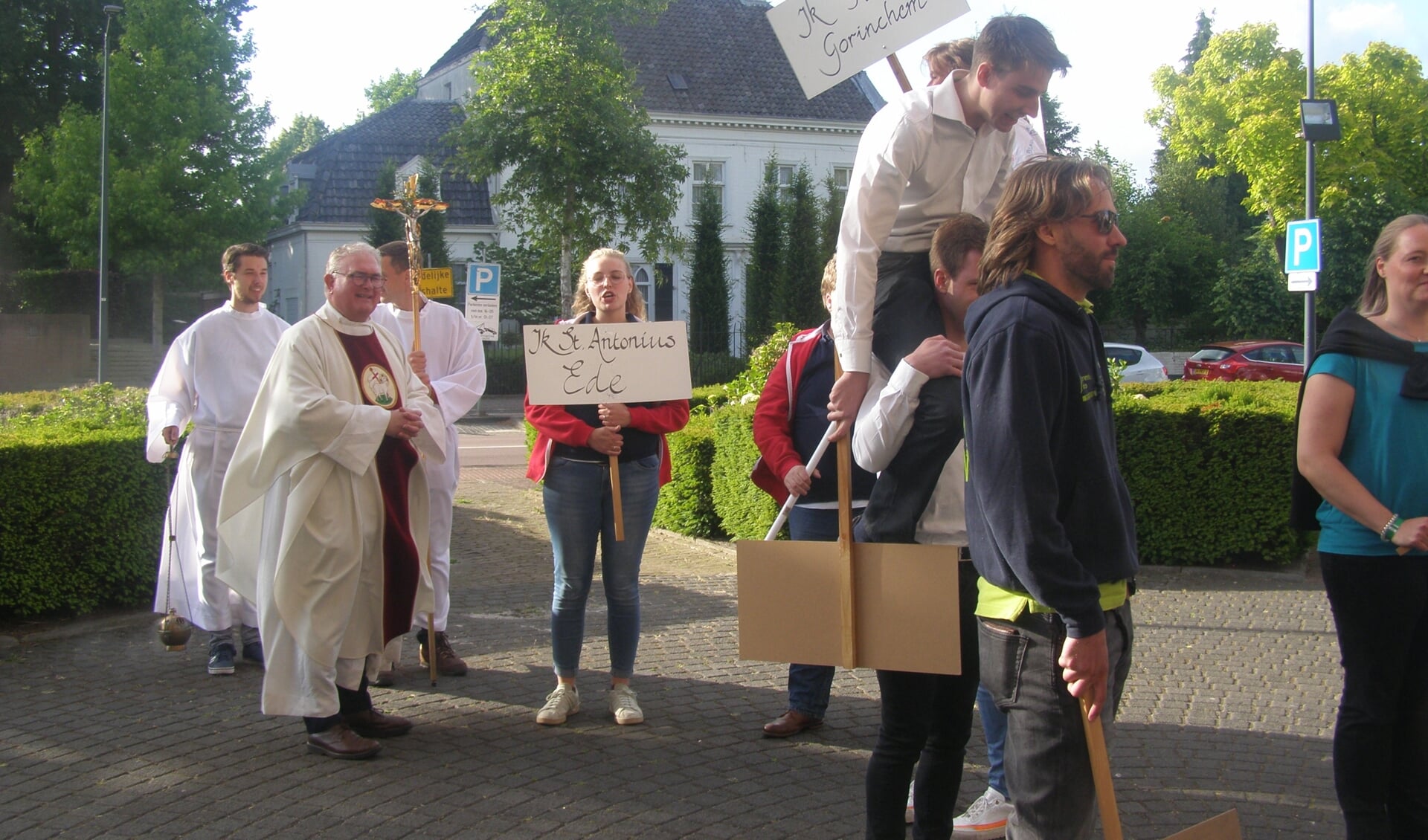 Afgevaardigden van de koren maken onder toeziend oog van pastoor Hans van Geel hun entree in de Sint Bavokerk. 