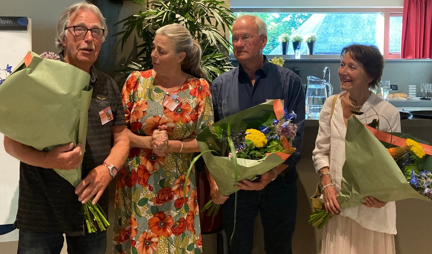 Christiaan Schraven (l), Willem Nagtzaam (2e van links) en Saskia Dado-Stoop (r) met de bloemen die zij van hun opvolgers ontvingen als dank voor hun inzet voor Ulvenhout uit de Kunst