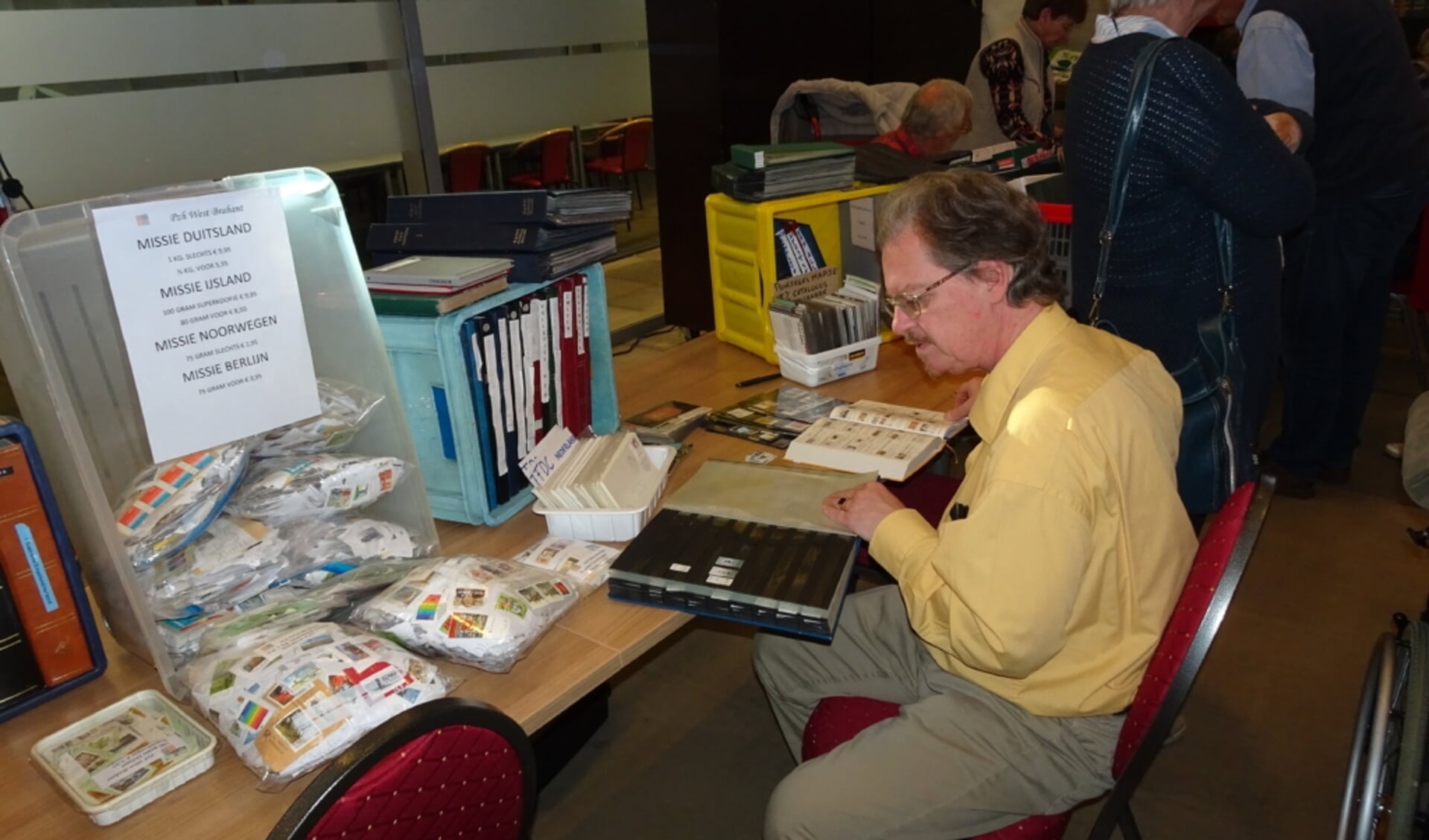 Postzegelverzamelaar zoekt postzegels voor zijn verzameling.