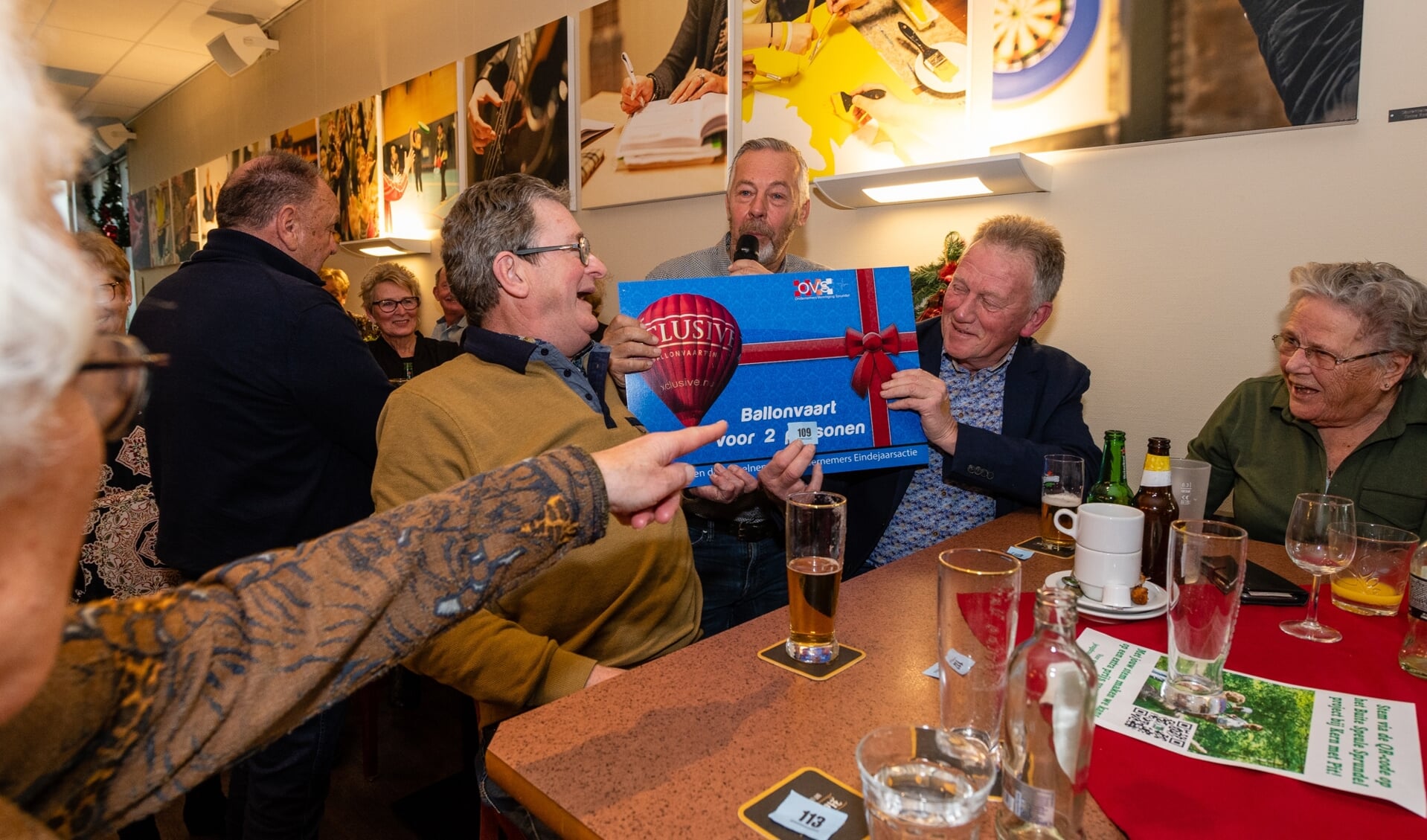 Frans en Wim Aarts ontvangen een cheque voor een ballonvaart voor twee personen.