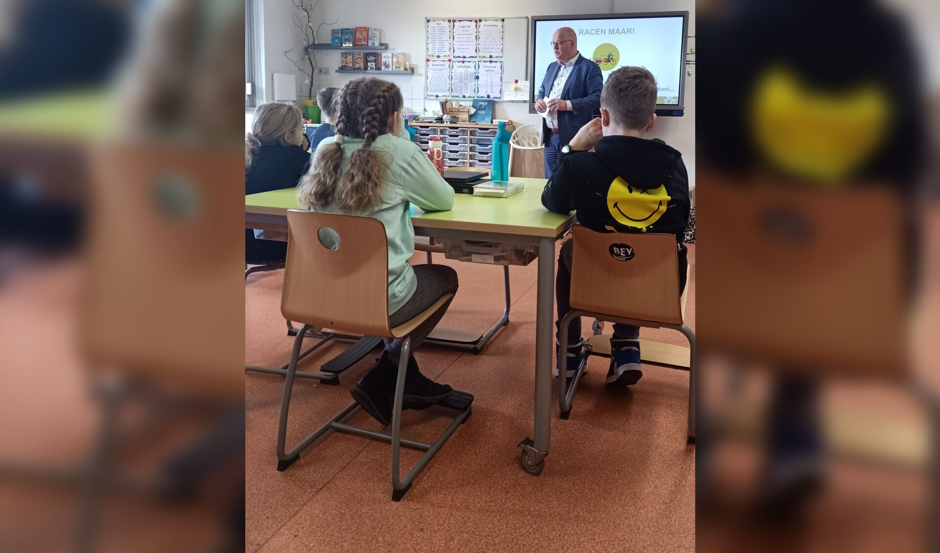 Wethouder Kees Weststrate vertelt in de klas bij de Regenboog over afval.