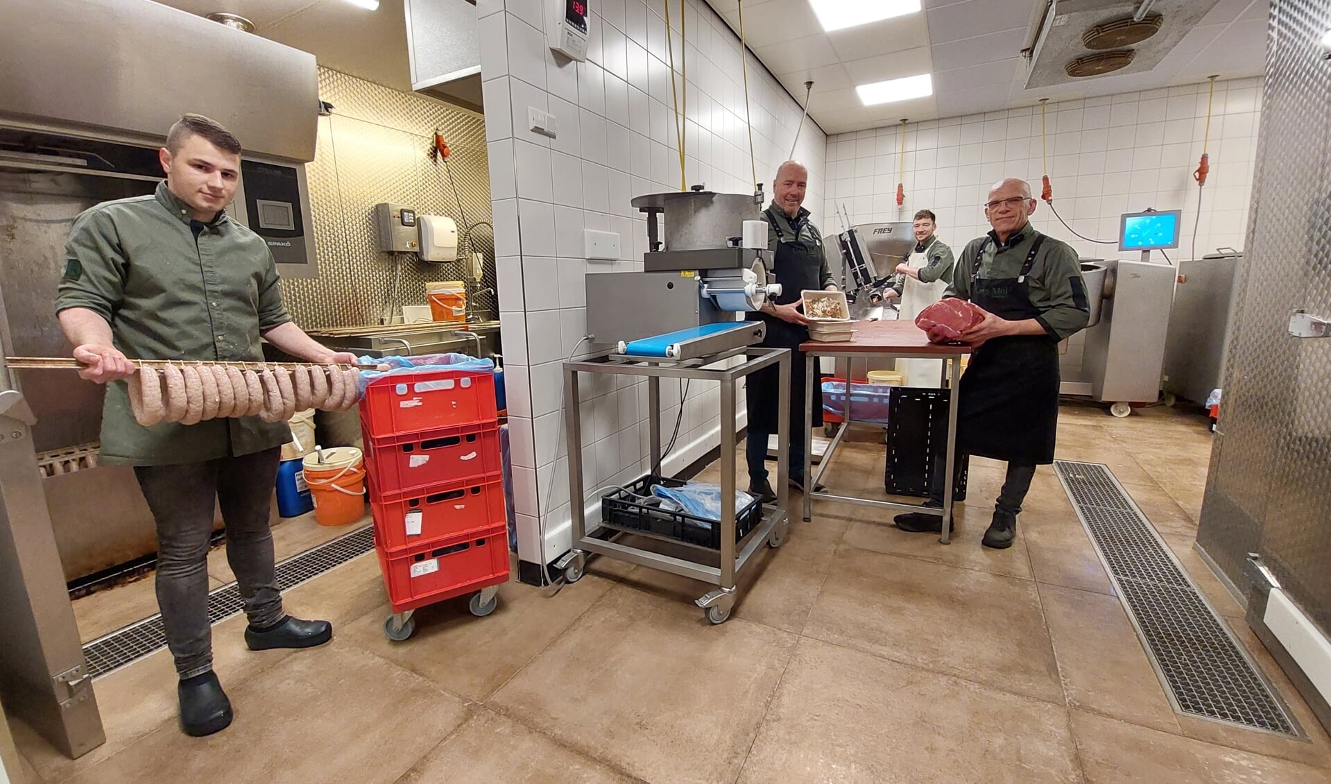 Cees Mol (tweede van links) met een deel van zijn team in de slagerij.