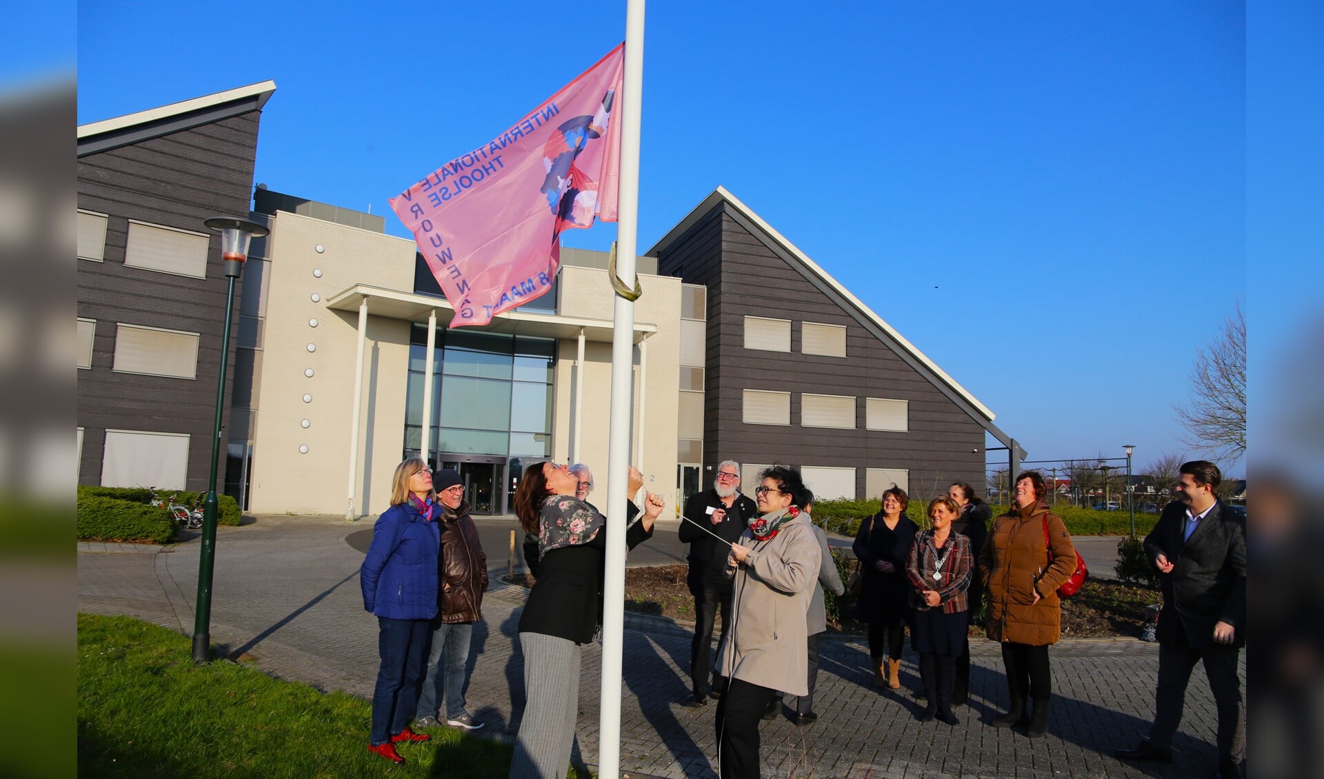 De vlag gaat de lucht in bij het gemeentehuis.
