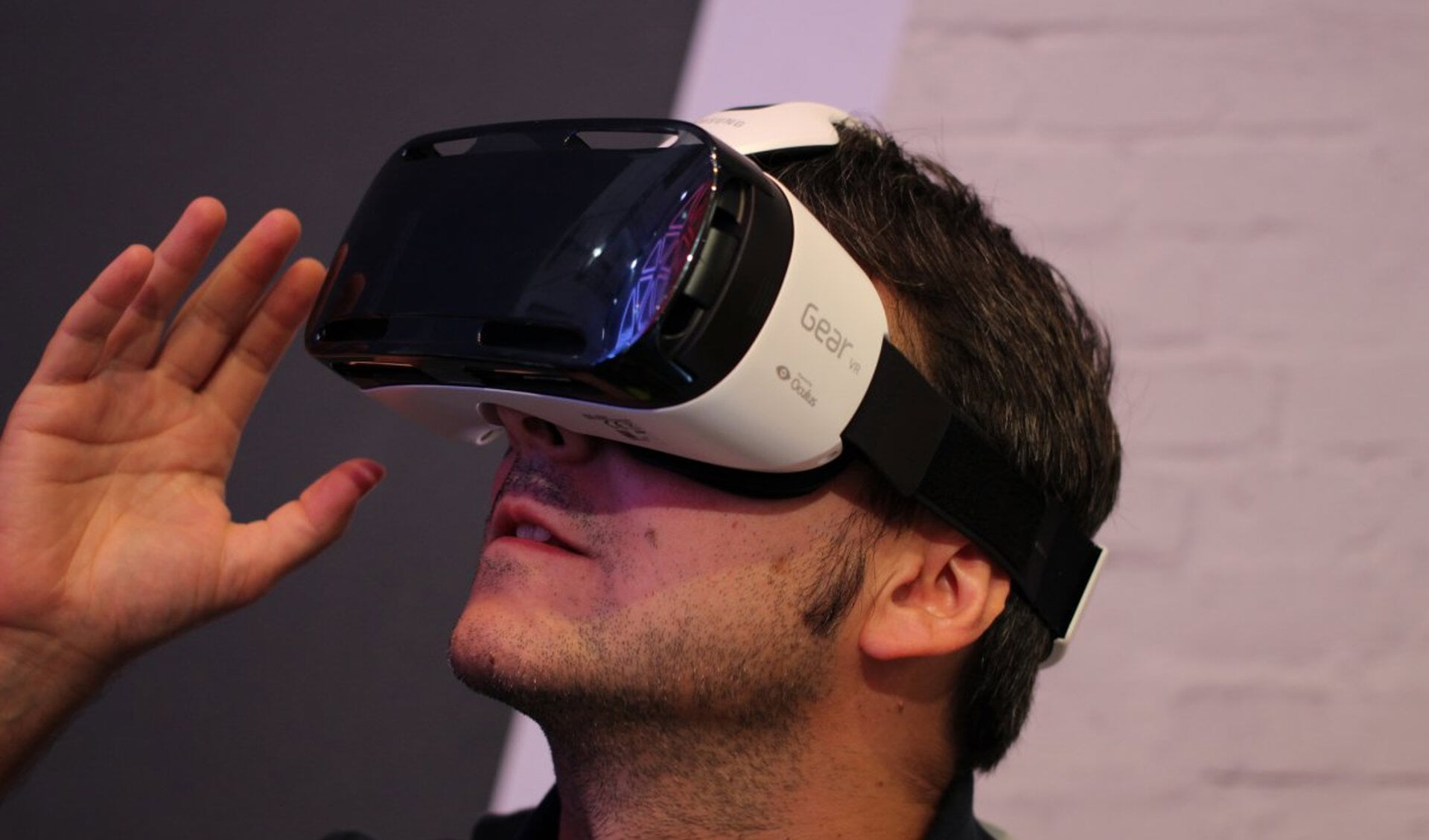 Een man bekijkt VR met een speciale bril voor een Samsung-telefoon.