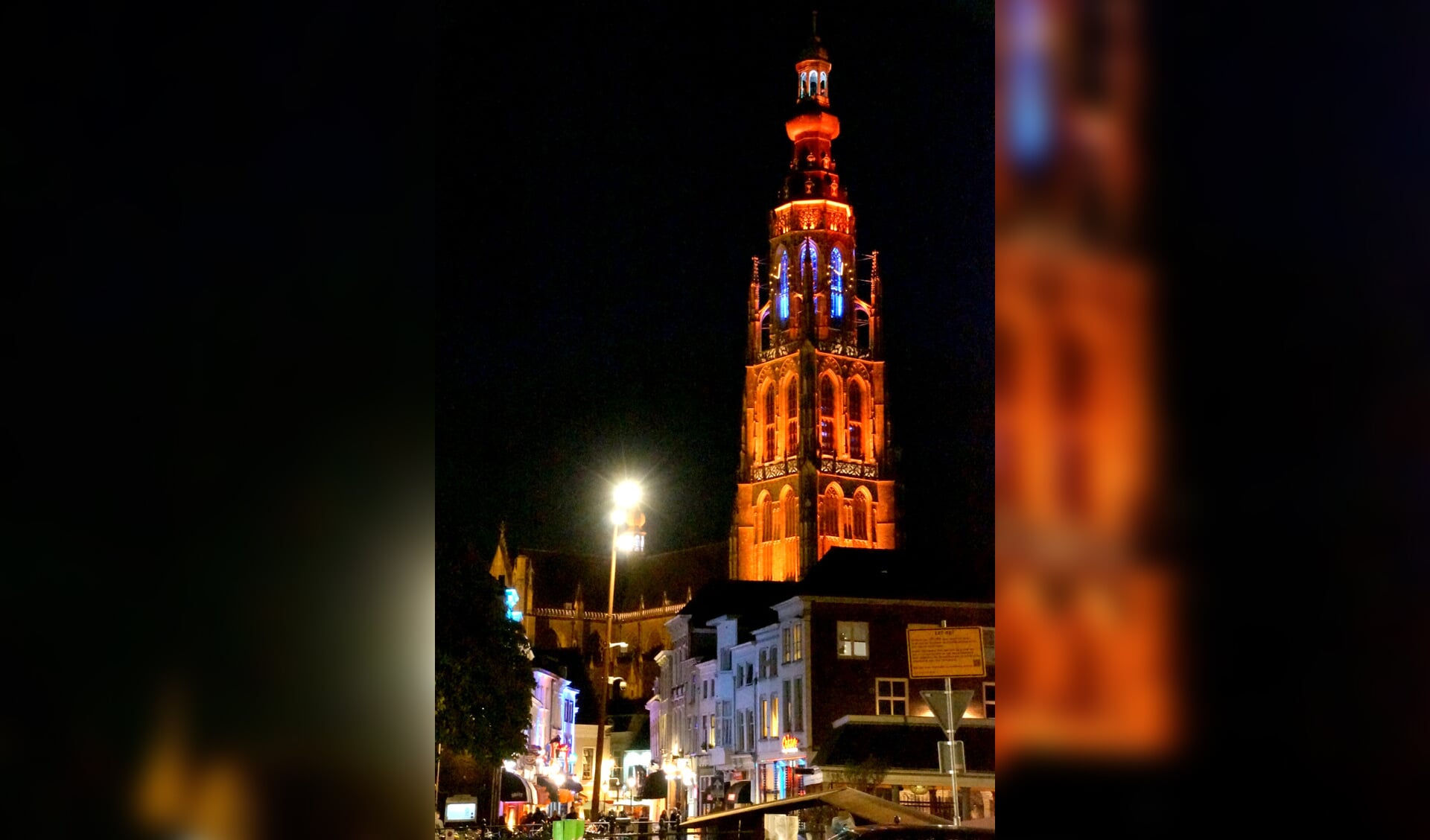 De Grote Kerk in een oranje gloed op Koningsnacht 2017.