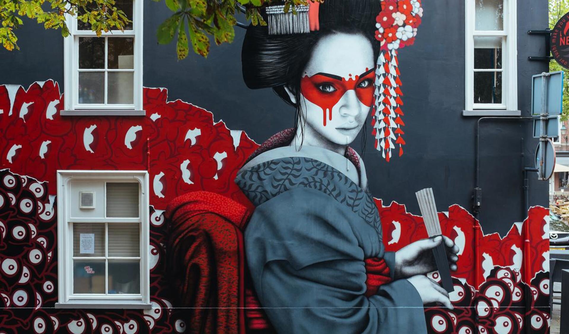 Streetartist Finnbar heeft een muur van de sushibar op de Ginnekenmarkt omgetoverd tot een grote Geisha.