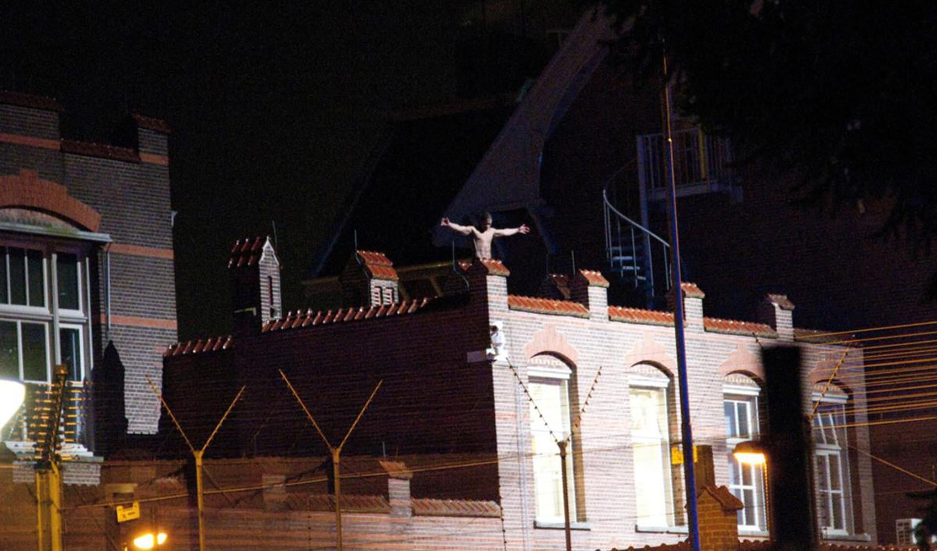 Dinsdag 13 maart. Een ontsnapte gevangene heeft zich op het dak van Den Hey-Acker verschransd. foto Perry Roovers