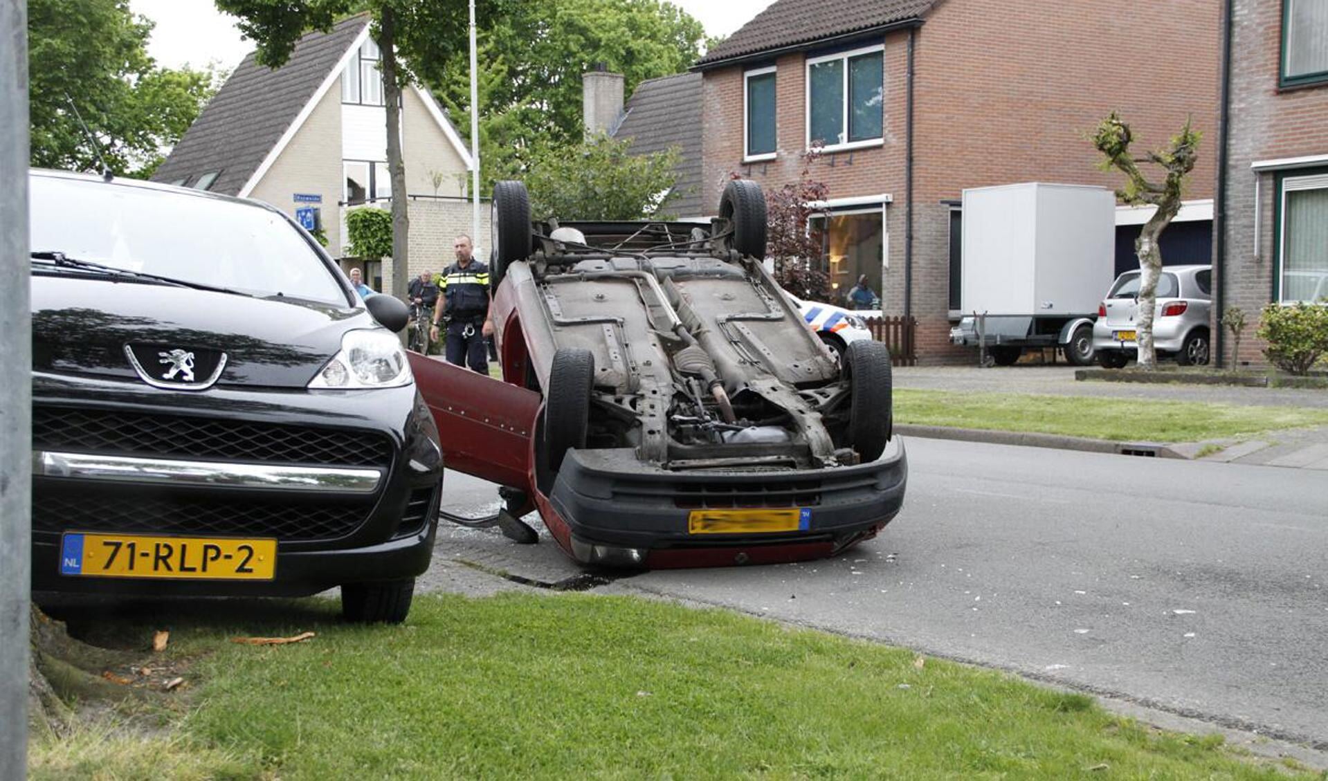 Een automobilist is door onbekende oorzaak tegen een geparkeerde auto gereden. Daarbij vloog hij over de kop.
