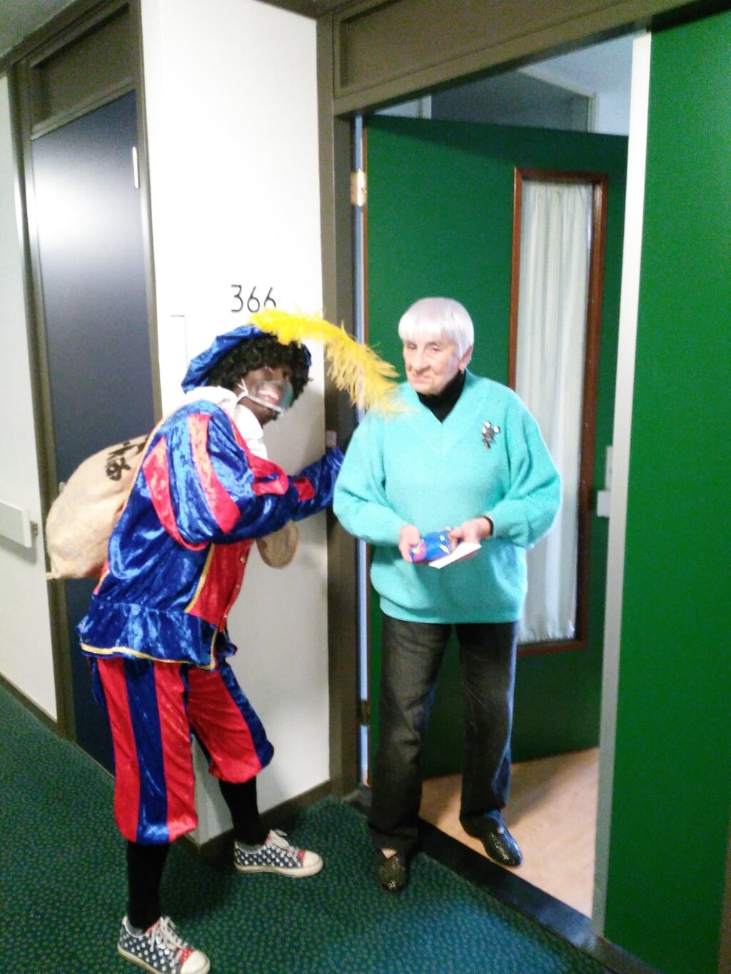 Zwarte Piet bij een Zonnebloemgast aan de deur