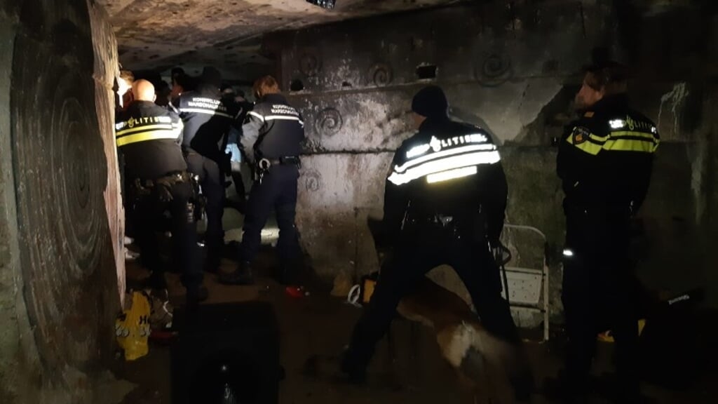 Agenten gaan met politiehonden de bunker in.
