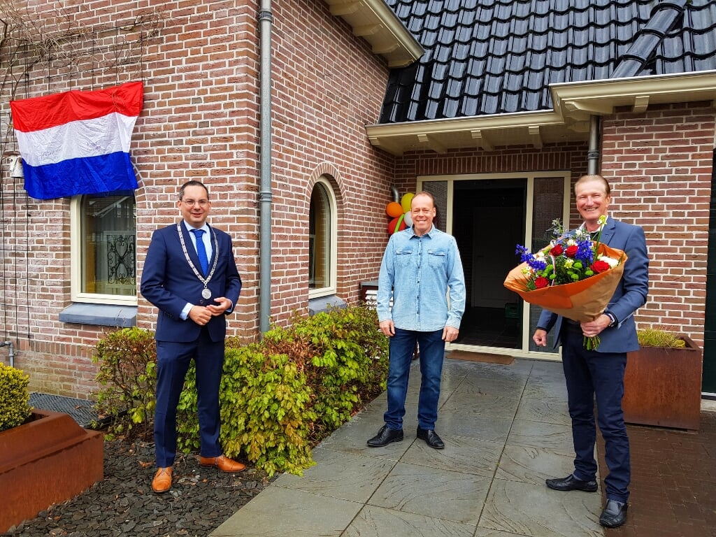 Ludo Kools ontvangst een bos bloemen uit handen van burgemeester Steven Adriaansen en wethouder Hans de Waal.