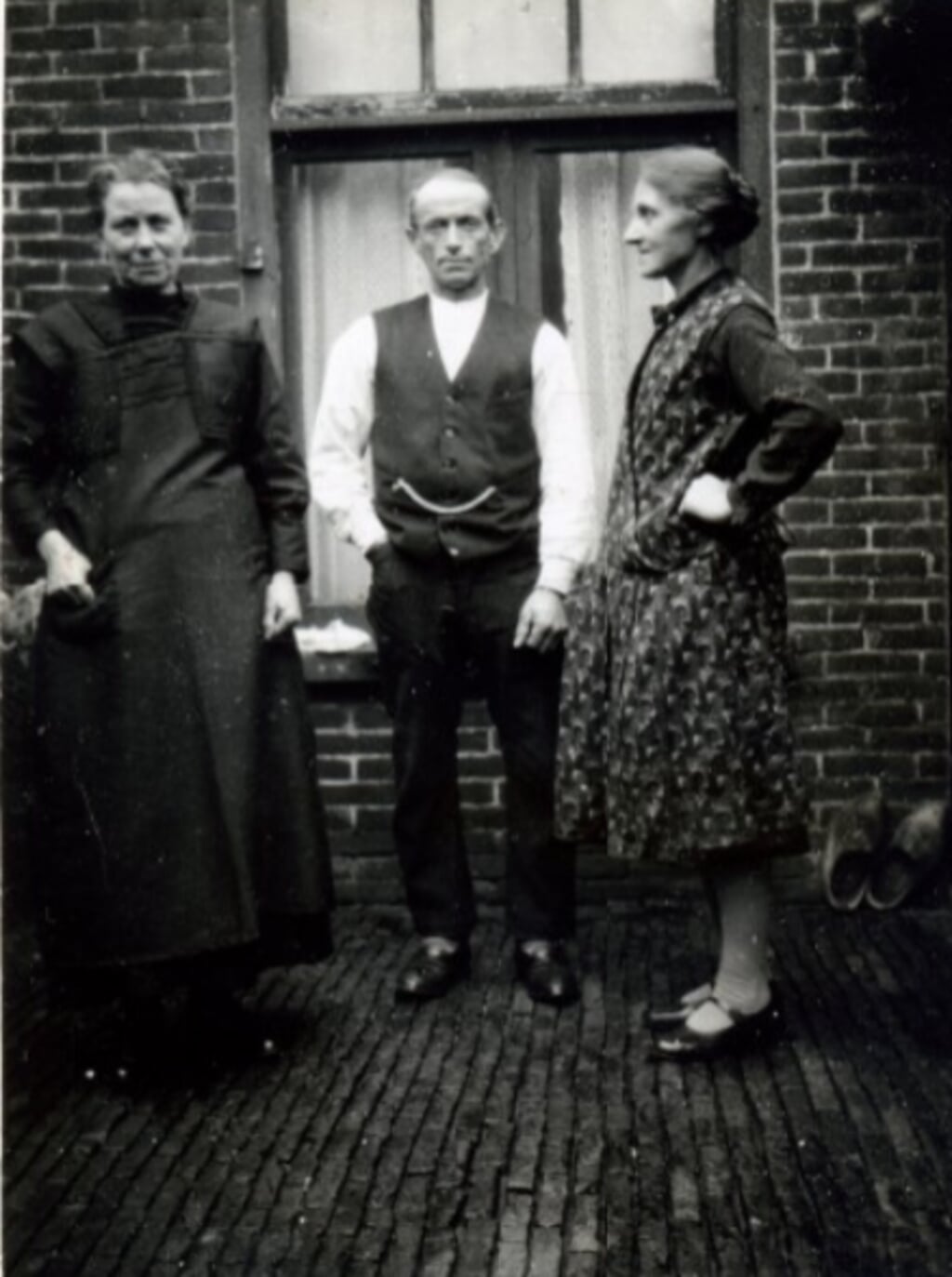 v.l.n.r. Jacoba van Beveren en Marinus J Neele en een onbekende achter het huis van de familie Neele aan de Molendijk rond 1935.