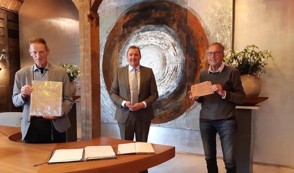 Ad Schenk, burgemeester Dijksterhuis en Kees Boonman (vlnr) bij enkele van de archiefstukken.