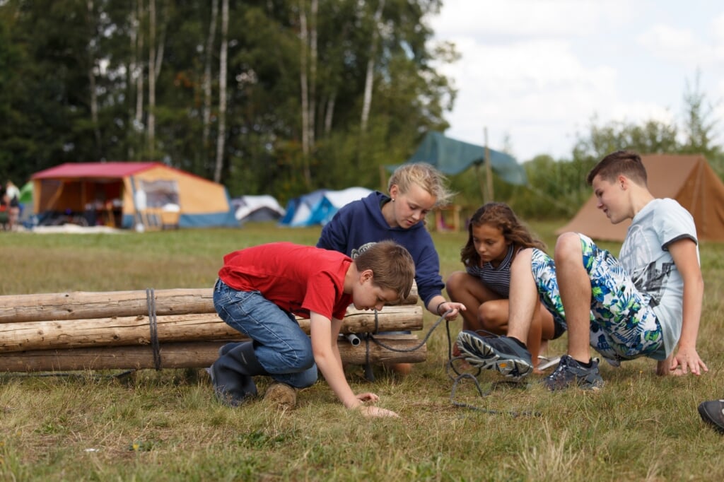 Scouts bouwen een vlot tijdens het zomerkamp.