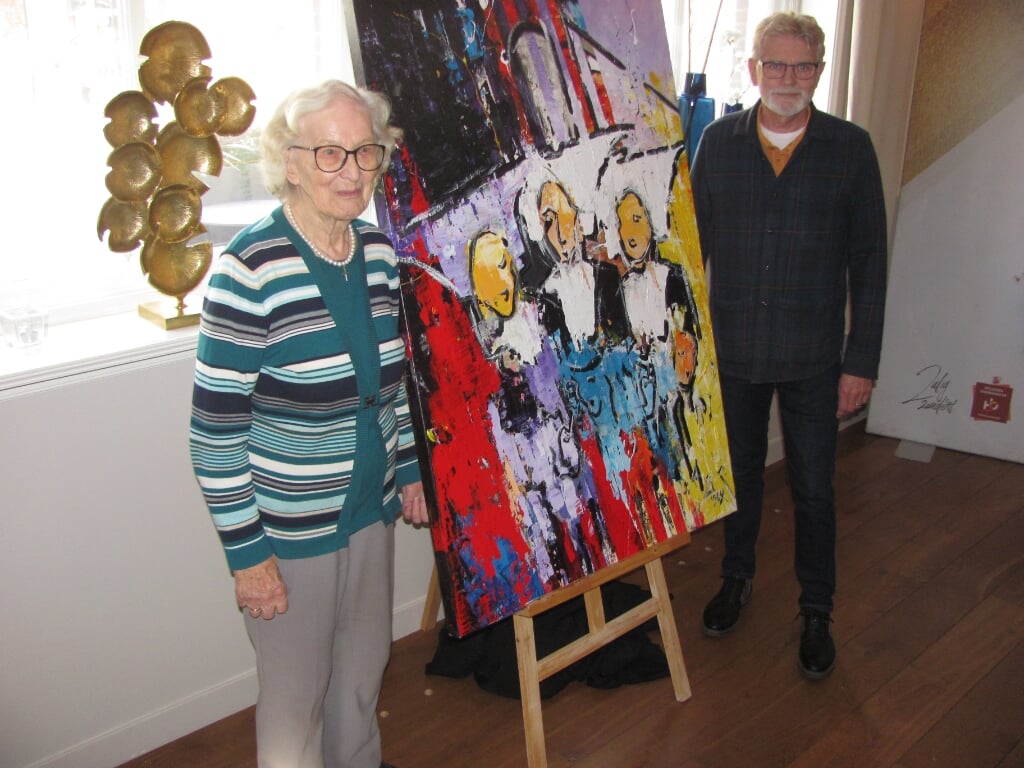 Zuster Therèse en beeldend kunstenaar Tom van Dessel poseren bij het schilderij.