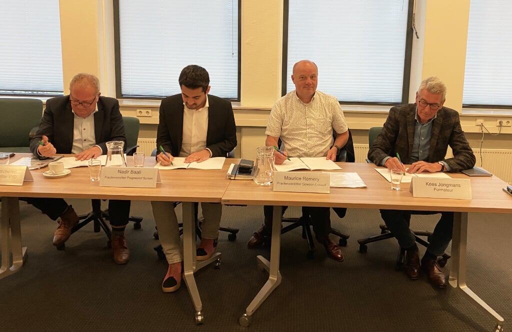De fractievoorzitters en de formateur ondertekenen het nieuwe coalitieakkoord.
