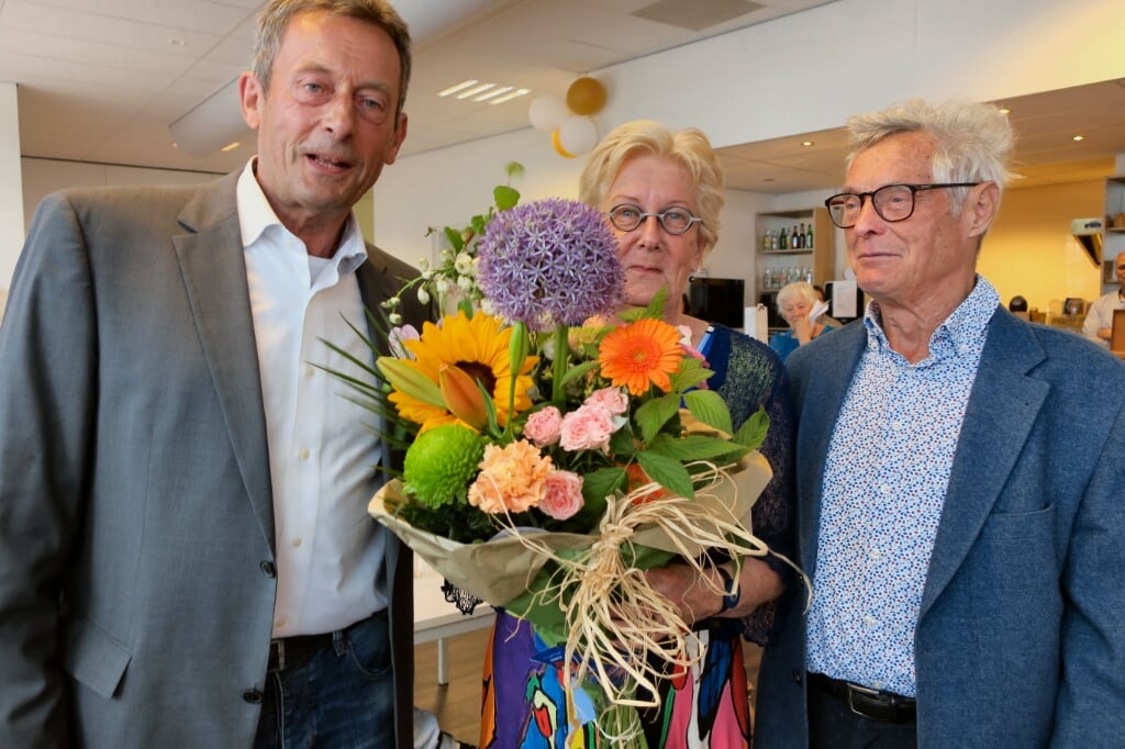 Voorzitter Philip Gravestein overhandigt bloemen aan Thecla en Tjeu Segers