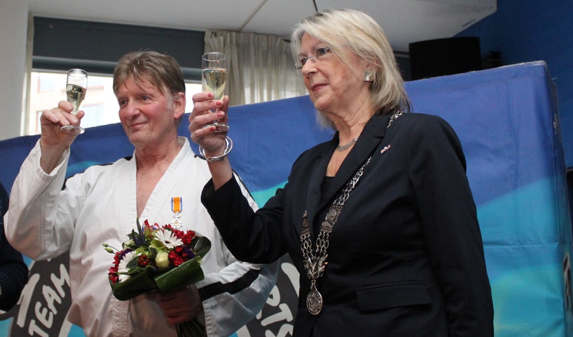 Jan Koster heft het glas met burgemeester Francisca Ravestein van Pijnacker die hem zojuist een Koninklijke onderscheiding heeft opgespeld (foto: Jan Wenteler)