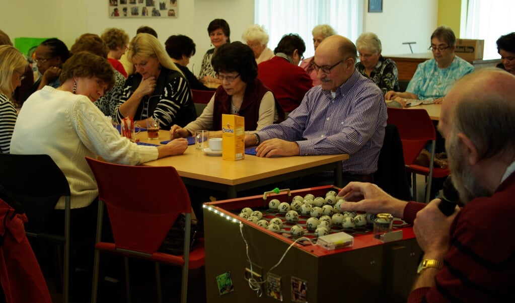 Joop Bommelé bestuurt de bingomachine. De enige mannelijke deelnemer heeft - net als alle vrouwen alleen oog voor z'n bingokaart. (foto: Jesper Neeleman)